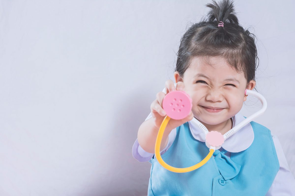 A little girl holding a toy stethoscope.