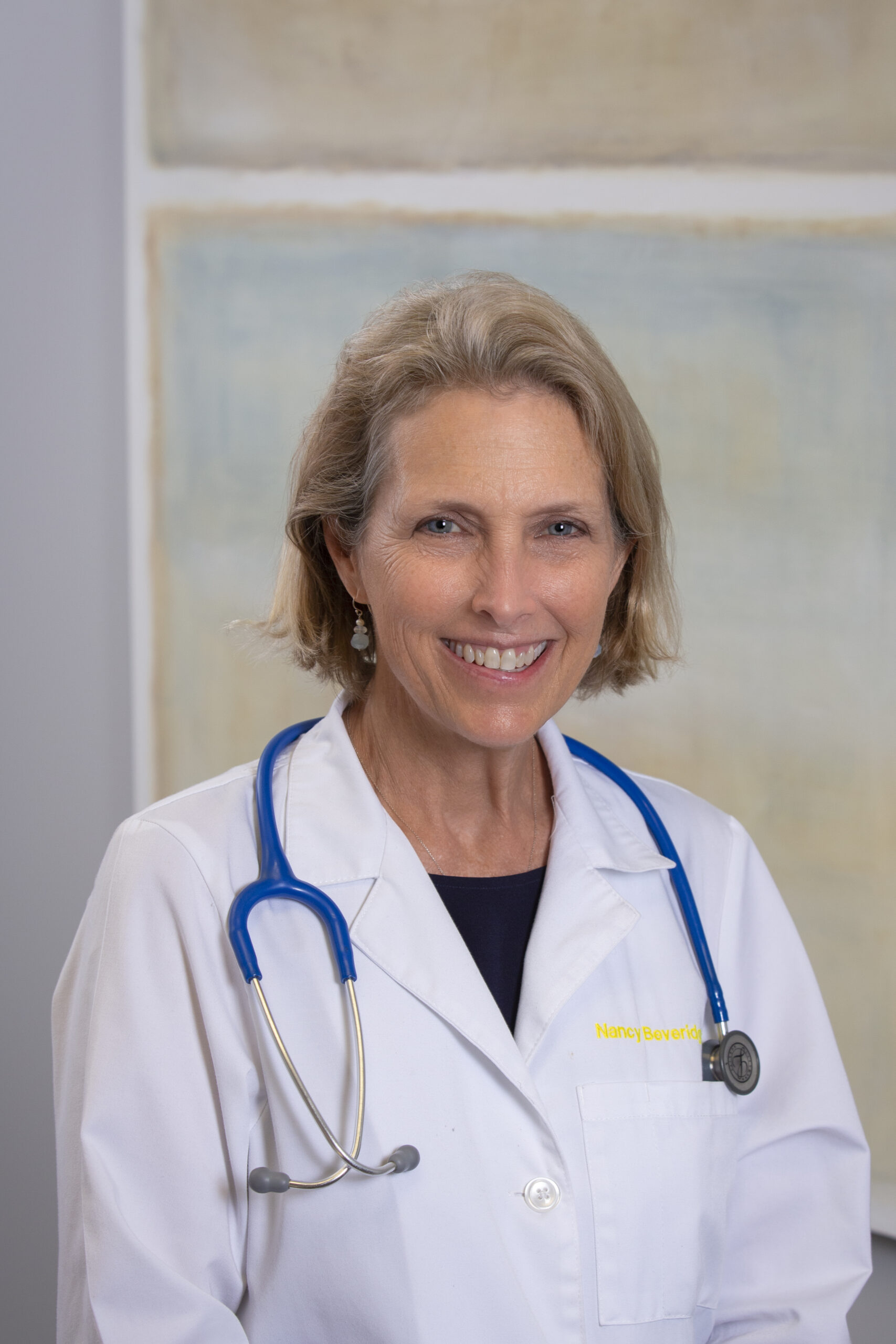 A woman in white lab coat with stethoscope.